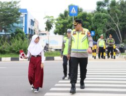 Kapolresta Barelang Bantu Siswa Menyeberang Jalan di Sungai Panas